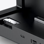 Close-up of a black electronic device with an open front drawer and a metal connector inside.