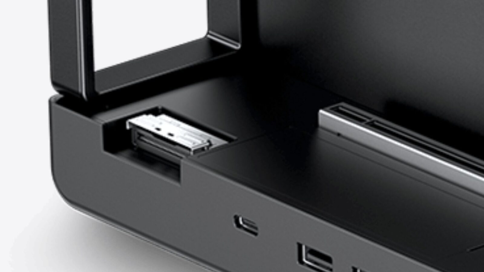 Close-up of a black electronic device with an open front drawer and a metal connector inside.