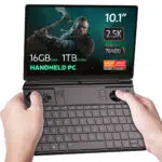 GPD-WIN-MAX-2-2023-LISTING-NEW-DONE-01.16-1 This image shows a GPD Win Max 2 2023, a handheld gaming PC. The screen highlights its key specifications, including a 10.1-inch display with a 2.5K resolution, 16GB of RAM, and 1TB of NVMe storage. It is powered by an AMD Ryzen 5 7640U processor from the Ryzen 7000 series and includes AMD Radeon graphics. The device has built-in gaming controls with joysticks, buttons, and a D-pad, along with a physical QWERTY keyboard for typing. The design suggests it’s tailored for both gaming and productivity, making it a versatile compact device.