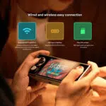 Close up of hands holding the AYANEO Pocket Micro displaying the game Balatro on screen Above icons represent connectivity features dual band WiFi 5 and BT 52 USB Type C interface and Micro SD card slot with brief descriptions of each features benefits