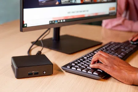 MiniPC next to a keyboard and monitor showcasing a small yet powerful device