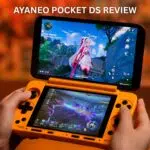 A close up image for a video review of the AYANEO POCKET DS handheld gaming console The device which has a bright orange clamshell design is held open in two hands The top screen displays a third person view of a female anime character in a bright fantasy world while the smaller bottom touchscreen displays a darker action scene with glowing effects Large white text overlaid on the image reads AYANEO POCKET DS REVIEW The background is a blurred orange and brown surface