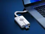 Close-up of the Biwin Mini SSD Reader connected to a laptop via a short USB-C cable, demonstrating a small form-factor Biwin SSD card being inserted into the reader's slot.