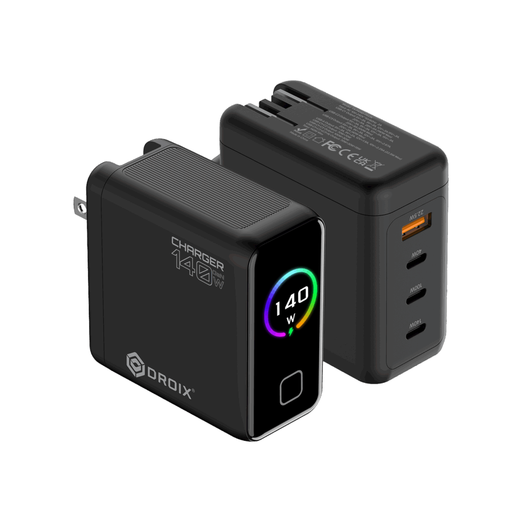 DROIX 140W USB-C Wall Charger 1 A detailed product render of two DROIX 140W GaN Wall Chargers from different perspectives, displayed on a black background. The foreground charger is in a front-three-quarter view. It is a matte black block with its US foldable plug partially extended on the left side. On its side, prominent white text reads "CHARGER 140W" with a large "O" and a small "140" above the "O," and the DROIX logo below it. The front glossy black face features a central circular display with a dynamic rainbow-colored ring around the white text "140 W" and a small green charging icon. Below the display is a button or LED indicator. The background charger is in a rear-three-quarter view, showing the ports and text details. It lists extensive multi-line technical specifications and safety certifications in small white text (such as model numbers, voltage/current ratings, and CE, FCC, UKCA marks). This unit displays its four output ports: from top to bottom, one orange-accented USB-A port labeled with small text "22.5W Max," followed by three USB-C ports labeled in order "40W", "100W", and "140W". Both units show top ventilation grills. This composition provides a comprehensive view of the charger's branding, display, and port capabilities.